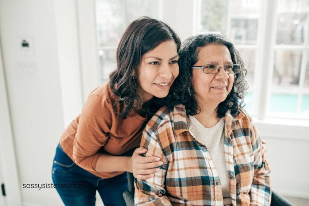 adult daughter helps her mom do her hair and then shows her in the mirror.
