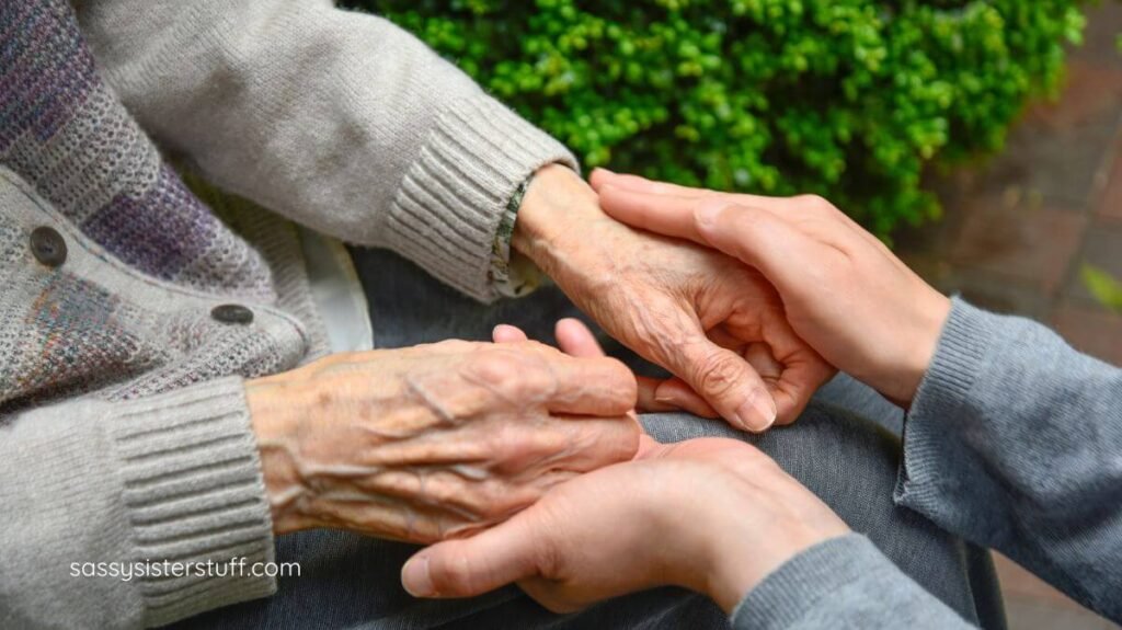 close up of a caregiver and elderly person with dementia holding hands.