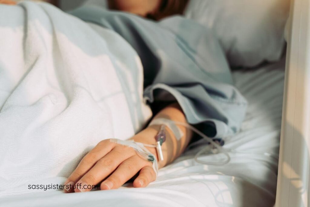 female laying in a hospital bed with several IVS.