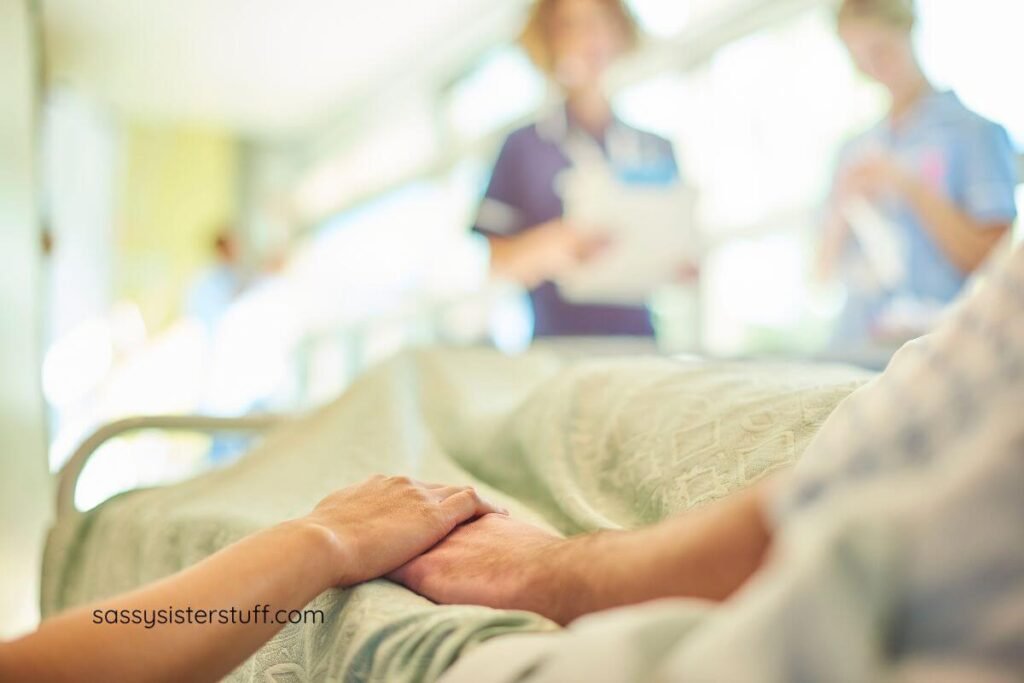adult daughter holding her elderly mother's hand as she lay in a hospital bed.