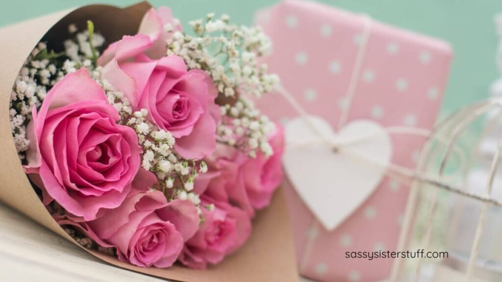 roses and a gift wrapped in pink gift wrap.