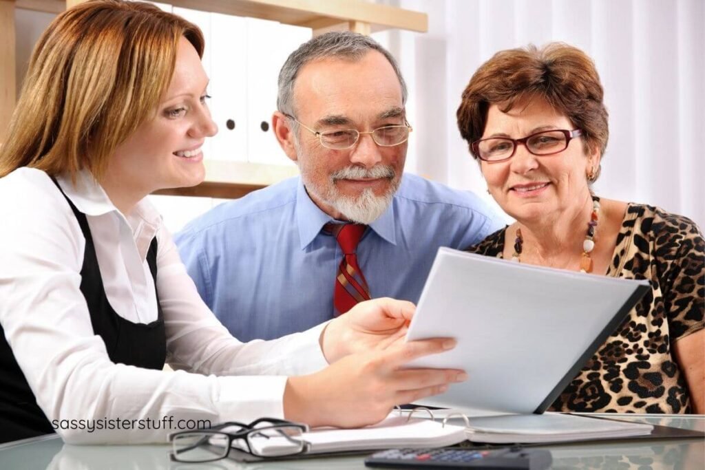 middle aged woman talks to an elderly couple about financial planning.