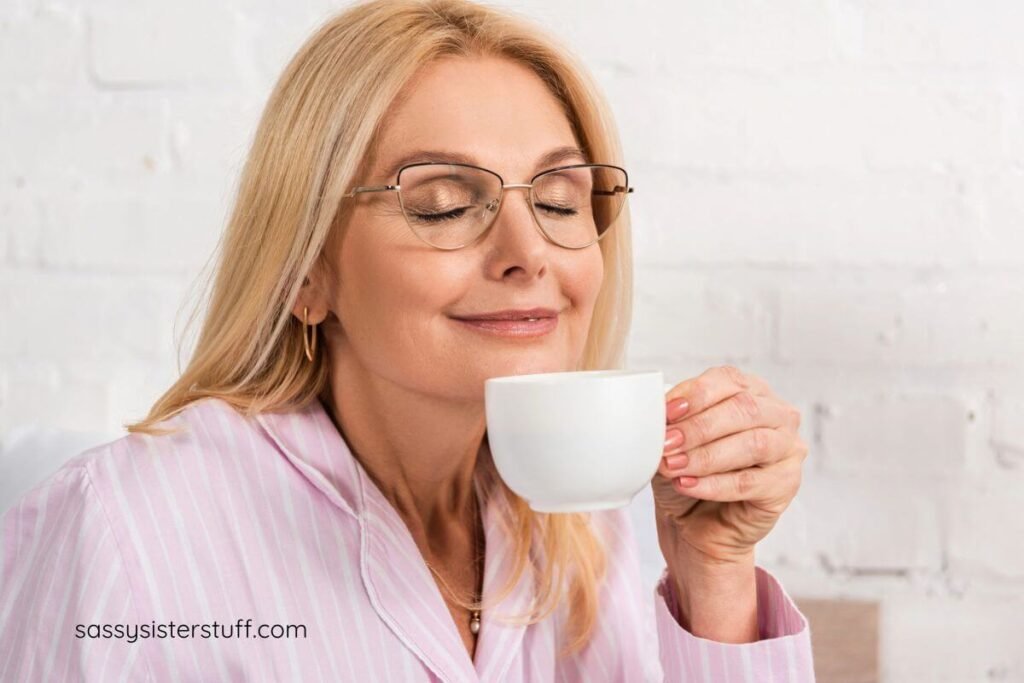 middle aged woman in comfortable pajamas that help caregivers unwind having her morning coffee after a great sleep.