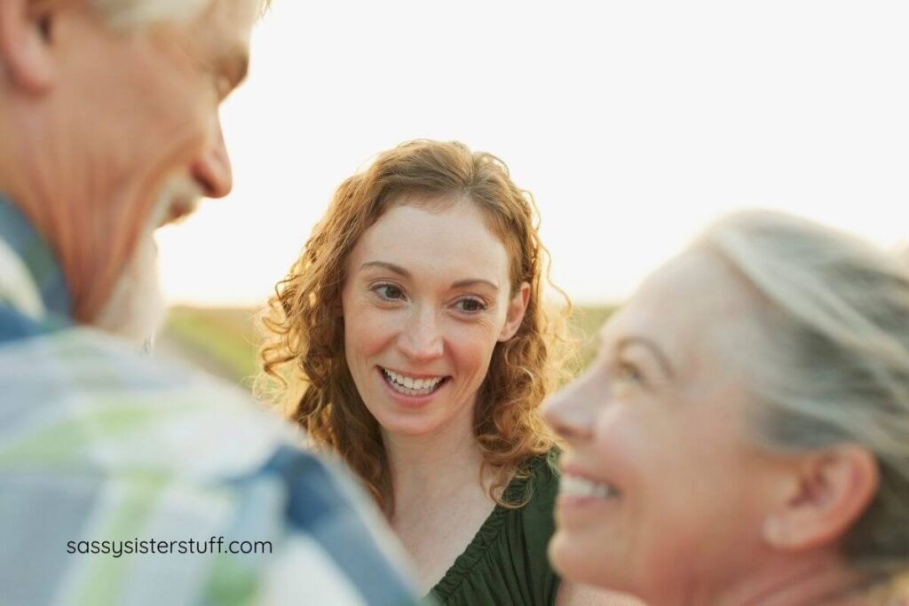 a grown adult woman smiles charmingly at her aging parents.