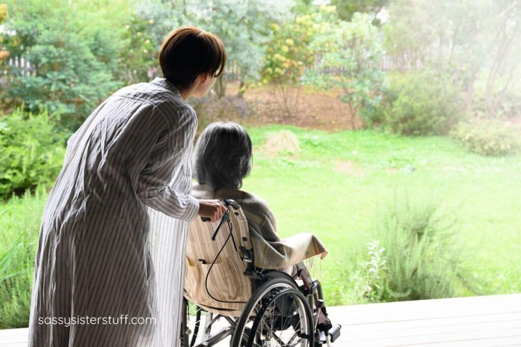 elderly mom in a wheelchair is pushed by her adult daughter in a beautiful green garden.