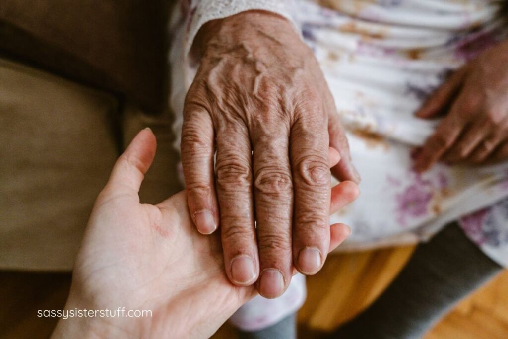 close up of a aging female hand being held by a younger hand.