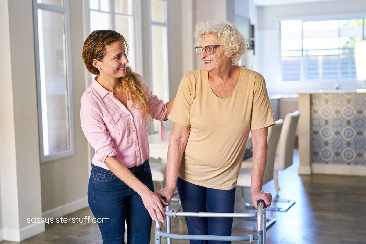 adult daughter helps her senior mother learn to use a walker.