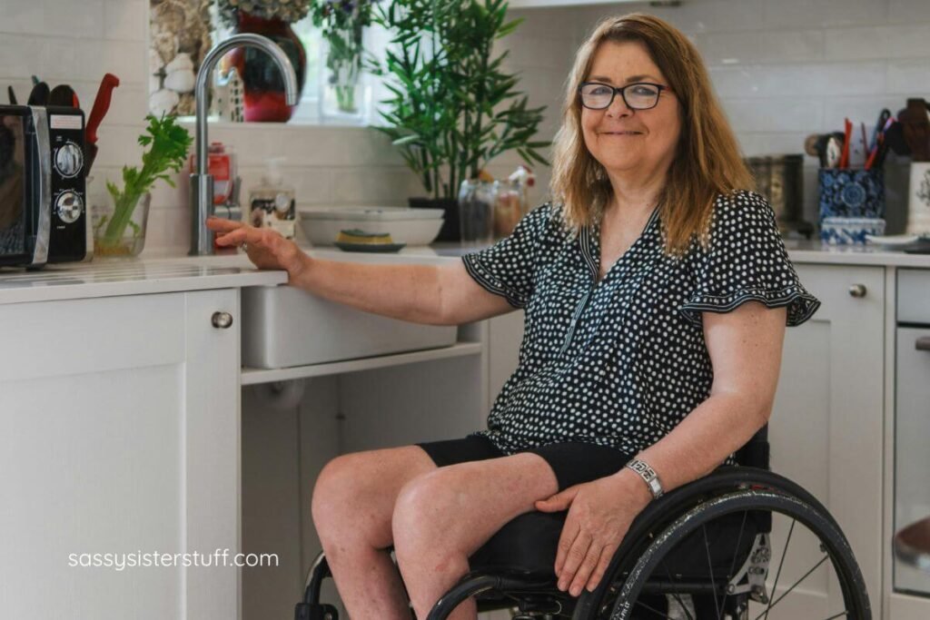 middle aged woman in a wheel chair accesses the counters in her kitchen.